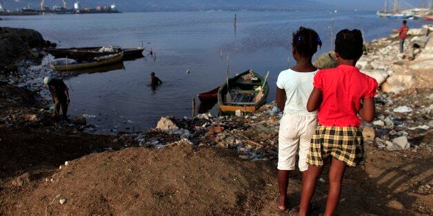 Two girls look at the harbor bay in Port-au-Prince, Haiti, Saturday, Oct. 24, 2015. More than 5½ years since Haiti suffered