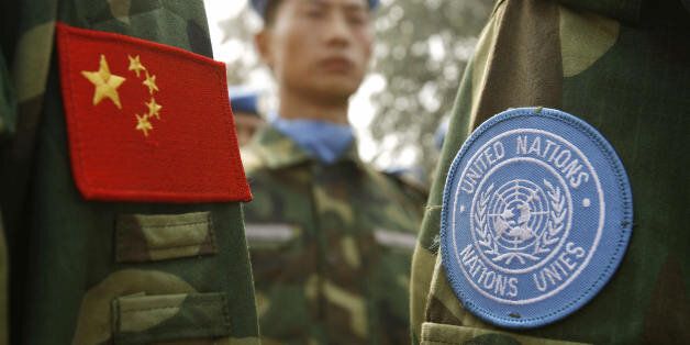People's Liberation Army (PLA) soldiers wear the sky-blue United Nations (UN) patch signifying membership in a Chinese peacekeeping unit destined for Darfur in the Sudan along with the Chinese flag on their uniforms, at their base in China's central Henan province 15 September 2007. A 315-member engineering unit is shipping out next month in China's latest attempt to play down accusations it is worsening Darfur's agony by supporting the Khartoum regime. The unit will build bridges and roads, dig wells and perform other tasks as they showed they mean business at the military training facility. AFP PHOTO/Peter PARKS (Photo credit should read PETER PARKS/AFP/Getty Images)