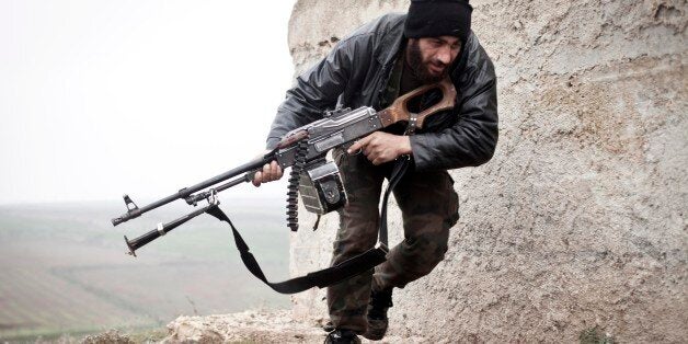 FILE - In this December 17, 2012 file photo, a Free Syrian Army fighter takes cover during fighting with the Syrian Army in Azaz, Syria. When Russian Foreign Minister Sergey Lavrov said his country is ready to aid Syrian rebels fighting Islamic State militants on the ground, rebel commanders scoffed at the notion, pointing out that Russian aircraft were pounding rebel bases in central and northern Syria on daily basis. (AP Photo/Virginie Nguyen Hoang, File)