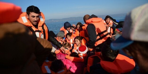 Migrants and refugees arrive on the Greek island of Lesbos after crossing the Aegean Sea from Turkey on November 18, 2015. L