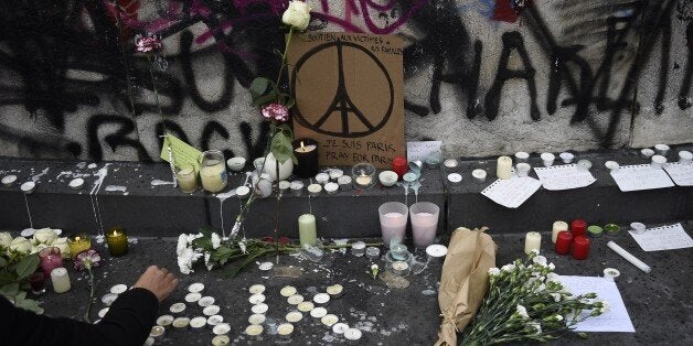 People law flowers and light candles at the Place de la Republique square in Paris on November 14, 2015, following a series of coordinated attacks in and around Paris late on November 13. At least 128 people were killed in the Paris attacks on the evening of November 13, with 180 people injured, 80 of them seriously, police sources told AFP. AFP PHOTO / MARTIN BUREAU (Photo credit should read MARTIN BUREAU/AFP/Getty Images)