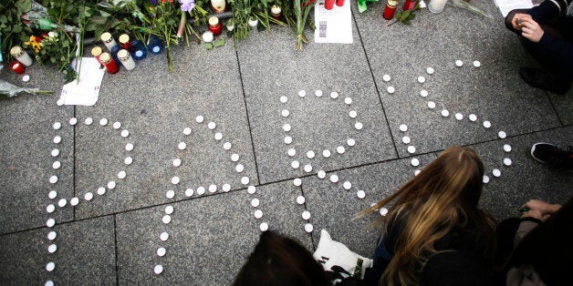 Young women have formed the word Paris with candles to mourn for the victims killed in Friday's attacks in Paris, France, i