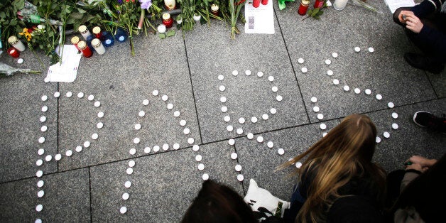 Young women have formed the word Paris with candles to mourn for the victims killed in Friday's attacks in Paris, France, in front of the French Embassy in Berlin, Saturday, Nov. 14, 2015. French President Francois Hollande said more than 120 people died Friday night in shootings at Paris cafes, suicide bombings near France's national stadium and a hostage-taking slaughter inside a concert hall. (AP Photo/Markus Schreiber)