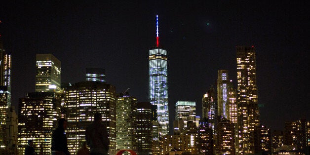 The One World Trade Center spire is lit blue, white and red after New York Gov. Andrew Cuomo announced the lighting in honor of dozens killed in the Paris attacks Friday, Nov. 13, 2015, in New York. French officials say several dozen people have been killed in shootings and explosions at a theater, restaurant and elsewhere in Paris. (AP Photo/Kevin Hagen)