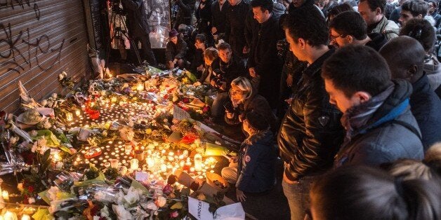 PARIS, FRANCE - NOVEMBER 14: Citizens who gathered around 'La Belle Equipe' leave flowers and light candles in front of the r