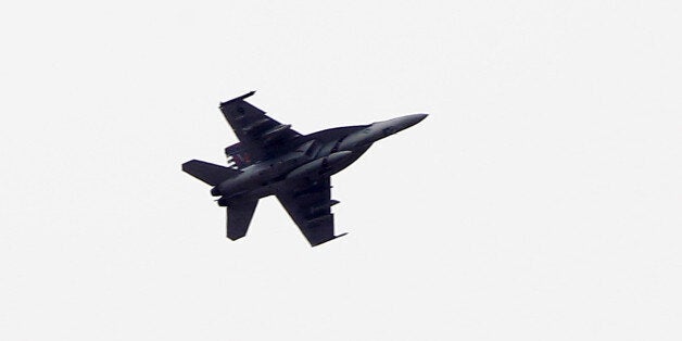 SANLIURFA, TURKEY - OCTOBER 19: (TURKEY OUT) A fighter jet flies above the Syrian town of Kobani on October 19, 2014 in Sanliurfa, Turkey. Kurdish fighters in Syrian city of Kobani have pushed back Islamic State militants in a number of locations as U.S. air strikes on ISIS positions continue in and around the city. In the past month more than 200,000 people from Kobani have fled into Turkey. (Photo by Gokhan Sahin/Getty Images)