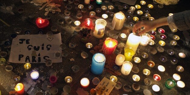 A person lights a candle on November 15, 2015 at a makeshift memorial in the 'Vieux port' of Marseille, for the victims of No