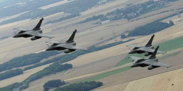 A picture taken on July 14, 2015 from a French Air Force C-135 FR refueling tanker aircraft shows four French Rafale fighter jets flying over the countryside, west of Paris, on their way to take part in the aerial Bastille Day military parade over Paris on July 14, 2015. AFP PHOTO / FRANCK PENNANT (Photo credit should read FRANCK PENNANT/AFP/Getty Images)