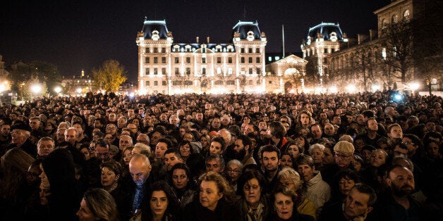 PARIS, FRANCE - NOVEMBER 15: People gather outside of Notre Dame Cathedral ahead of a ceremony to the victims of the Friday's terrorist attacks on November 15, 2015 in Paris, France. As France observes three days of national mourning members of the public continue to pay tribute to the victims of Friday's deadly attacks. A special service for the families of the victims and survivors is to be held at Paris's Notre Dame Cathedral later on Sunday. (Photo by David Ramos/Getty Images)