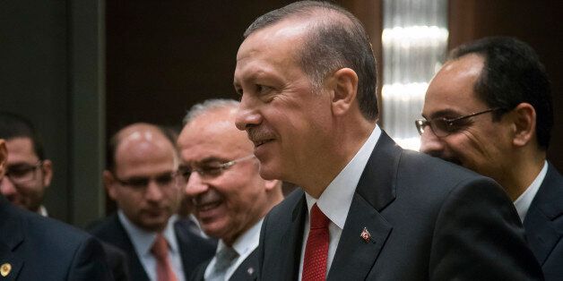 Turkish President Recep Tayyip Erdogan holds a peach as he arrives to meet with Russian President Vladimir Putin during the G-20 Summit in Antalya, Turkey, Monday, Nov. 16, 2015. (AP Photo/Alexander Zemlianichenko, Pool)