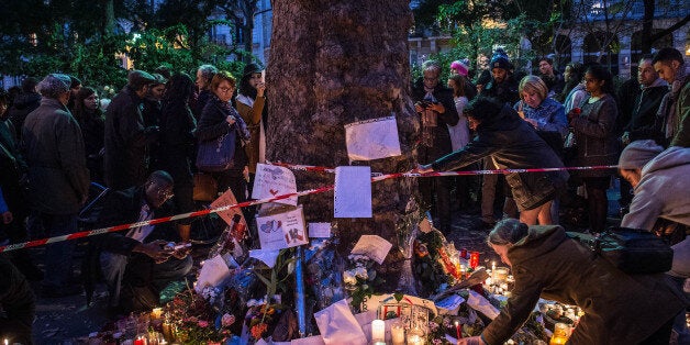 PARIS, FRANCE - NOVEMBER 16: People place flowers and candles in memory of the victims of Friday's attack in front of Batacl