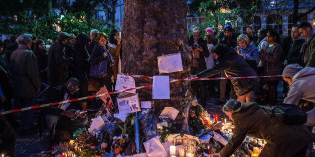 PARIS, FRANCE - NOVEMBER 16: People place flowers and candles in memory of the victims of Friday's attack in front of Bataclan concert hall on November 16, 2015 in Paris, France. A Europe-wide one-minute silence was held at 12pm CET today in honour of at least 129 people who were killed last Friday in a series of terror attacks in the French capital. (Photo by David Ramos/Getty Images)