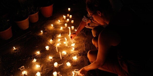 MANILA, PHILIPPINES - NOVEMBER 16: French nationals light candles to honour victims of the Paris terror attacks at Alliance