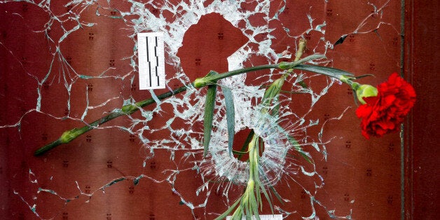 PARIS, FRANCE - NOVEMBER 15: Flowers are placed beside a bullet hole at 'Le Carillon' restaraunt on Rue Bichat following Fri