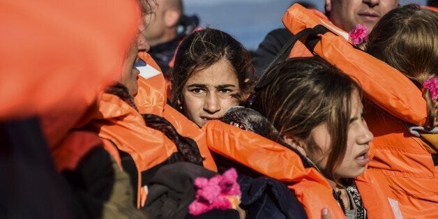 Migrants and refugees arrive on the Greek island of Lesbos after crossing the Aegean Sea from Turkey on November 18, 2015. L