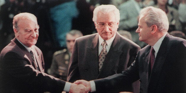 (FILES) This file picture taken 01 November 1995 during the start of the Proximity Peace Talks at Wright Patterson Air Force Base near Dayton shows Bosnian President Alija Izetbegovic (L) shaking hands with Serbian President Slobodan Milosevic (R) as Croatian President Franjo Tudjman watches. The Dayton peace accords, signed 21 November 1995, ended Bosnia's 1992-1995 war that claimed some 200,000 lives ended without a winner, complicating the task of rebuilding a viable state and sharing resources among the three main ethnic communities -- Croats, Muslims and Serbs. AFP PHOTO/FILES/JOE MARQUETTE (Photo credit should read Joe Marquette/POOL/AFP/Getty Images)
