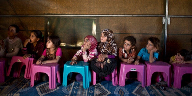 FILE - In this Wednesday, Oct. 21, 2015 file photo, Syrian refugee children attend a class at a makeshift school set up in a