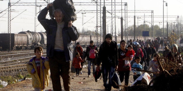 Migrants and refugees walk towards the border with Serbia, after arriving at the transit center for refugees near the village of Tabanovce, in northern Macedonia, Thursday, Nov. 19, 2015. Four nations along Europe's Balkan refugee corridor shut their borders Thursday to those not coming from war-torn countries such as Syria, Afghanistan or Iraq, leaving thousands of others seeking a better life in Europe stranded at border crossings. (AP Photo/Boris Grdanoski)