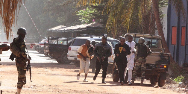 People run to flee from the Radisson Blu Hotel in Bamako, Mali, Friday, Nov. 20, 2015. The company that runs the Radisson Blu Hotel in Mali's capital says assailants have takenhostages in a brazen assault involving grenades. (AP Photo/Harouna Traore)