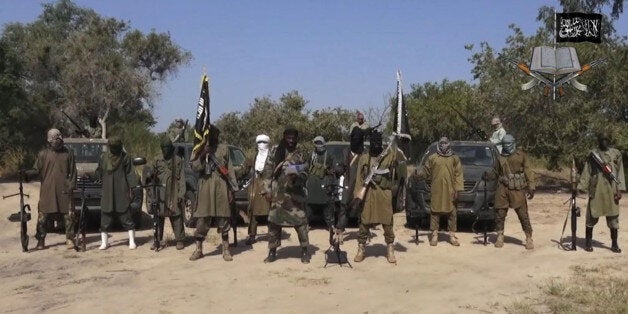 FILE - In his file image taken from video released late Friday evening, Oct. 31, 2014, by Boko Haram, Abubakar Shekau, centre, the leader of Nigeria's Islamic extremist group denies agreeing to any cease-fire with the government and says more than 200 kidnapped schoolgirls all have converted to Islam and been married off. Boko Haram leader Abubakar Shekau Tuesday Jan. 20, 2015 claimed responsibility for the mass killings in the northeast Nigerian town of Baga and threatened more violence. As many as 2,000 civilians were killed and 3,700 homes and business were destroyed in the Jan. 3, 2015, attack on the town near Nigeria’s border with Cameroon, said Amnesty International. (AP Photo/Boko Haram,File)