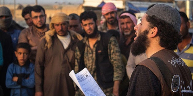 FILE -- In this file photo released May 14, 2015 by a militant website, which has been verified and is consistent with other AP reporting, a member of the Islamic State group'sÂ vice police known as "Hisba," right, reads a verdict handed down by an Islamic court sentencing many they accused of adultery to lashing, in Raqqa City, Syria. Islamic State militants are barricading down for a possible assault on their de facto capital Raqqa, hiding among civilian homes and preventing anyone from fleeing, as international airstrikes intensify on the Syrian city in the wake of the Paris attacks. For many, the threat of missiles and bombs from the enemies of Islamic State is more of an immediate threat than the vicious oppression of the jihadisâ themselves. (Militant website via AP, File)