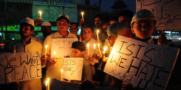 BHOPAL, INDIA - NOVEMBER 15: Muslim kids hold placards with slogans against the ISIS during a candle light vigil to express solidarity with the victims of Paris terror attacks on November 15, 2015 in Bhopal, India. At least 129 people lost their lives in terror attacks by terrorists in Paris at the packed Bataclan concert hall, restaurants and bars, and outside the Stade de France national stadium. The Islamist jihadist group IS, that has seized control of large parts of Syria and Iraq, claimed responsibility for the attacks. (Photo by Mujeeb Faruqui/Hindustan Times via Getty Images)