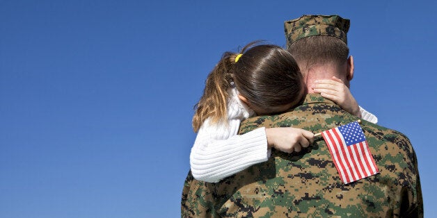 Military man hugs his child