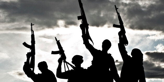 Silhouette of several muslim militants with rifles