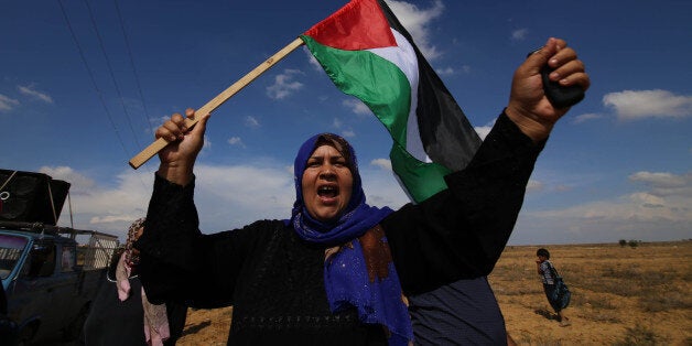 GAZA, Oct. 28, 2015-- A Palestinian woman waves national flag during an anti-Israel protest near the border between Israel and the southern Gaza Strip on Oct. 28, 2015. Since early October, 64 Palestinians were killed and more than 2,000 wounded in a wave of fierce confrontations and violence between Israel and the Palestinians all over the West Bank and Gaza Strip. (Xinhua/Khaled Omar via Getty Images)