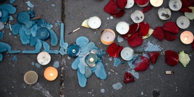 Candles and flower petals are left at the Place de la Republique in the French capital Paris, on November 23, 2015 as people