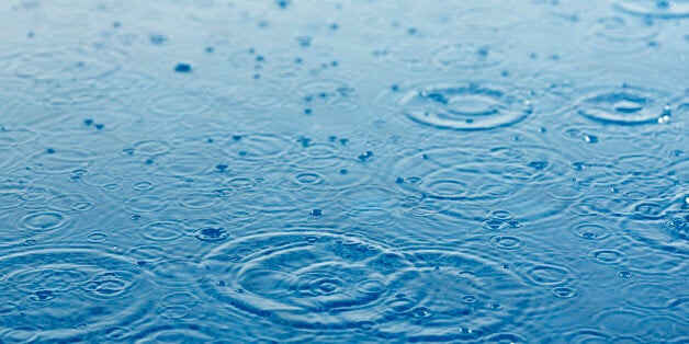 rain drops falling on the surface of water creating ripples