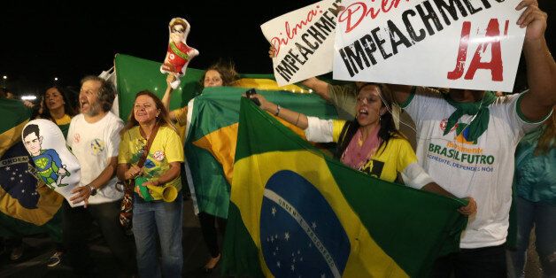 People demonstrate against the government as they take part in protest in favor of the impeachment of Brazil's President Dilma Rousseff, in front of the National Congress, in Brasilia, Brazil, Wednesday, Dec. 2, 2015. Impeachment proceedings were opened Wednesday against Brazilian President Rousseff by the speaker of the lower house of Congress, a sworn enemy of the beleaguered leader. The signs held by the demonstrators read in Portuguese "Dilma Impeachment Now." (AP Photo/Eraldo Peres)