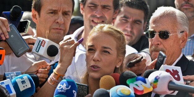 Venezuelan opposition leader and wife of jailed leader Leopoldo Lopez, Lilian Tintori (C) speaks to journalists accompanied by former Colombian president Andres Pastrana (R) and former Bolivian president Jorge Quiroga (L) after voting at a polling station in Caracas, on December 6, 2015. Venezuelans voted Sunday in tense elections that could see the opposition seize legislative power from the socialist government and risk sparking violence in the oil-rich, cash-poor nation. AFP PHOTO/ LUIS ROBAYO / AFP / LUIS ROBAYO (Photo credit should read LUIS ROBAYO/AFP/Getty Images)