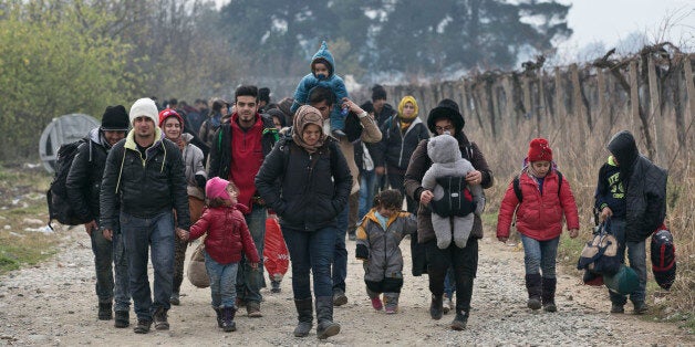 CORRECTS MONTH IN DATE Migrants and refugees walk towards a registration camp after entering Macedonia from Greece, near the southern Macedonian town of Gevgelija, Friday, Dec. 4, 2015. Greek riot police struggled to maintain order on Friday after clashes between asylum-seekers at the country's border with Macedonia. Macedonia is allowing only people from Afghanistan, Iraq and Syria to cross the border, and groups of people from other nationalities have set up makeshift roadblocks, preventing anyone from crossing. (AP Photo/Visar Kryeziu)