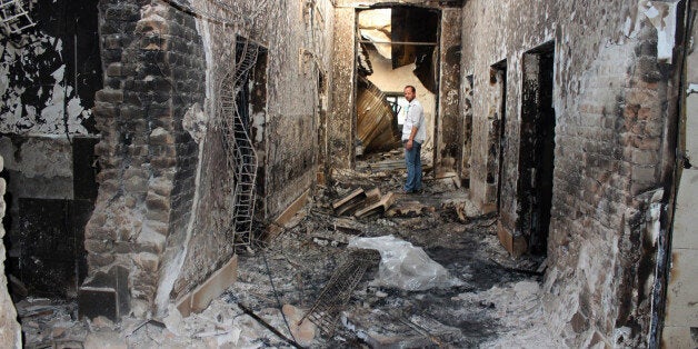 FILE - In this Oct. 16, 2015, file photo, an employee of Doctors Without Borders stands inside the charred remains of their h