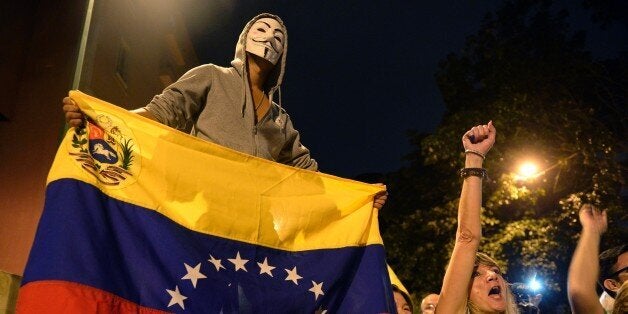 TOPSHOT - Venezuelan opposition supporters celebrate the results of the legislative election in Caracas, on the early morning December 7, 2015. Venezuela's opposition won --at least--a majority of 99 out of 167 seats in the state legislature, electoral authorities said Monday, the first such shift in power in congress in 16 years. AFP PHOTO/FEDERICO PARRA / AFP / FEDERICO PARRA (Photo credit should read FEDERICO PARRA/AFP/Getty Images)