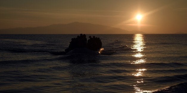 Refugees and migrants arrive on a boat to the Greek island of Lesbos after crossing the Aegean sea from Turkey on December 7,