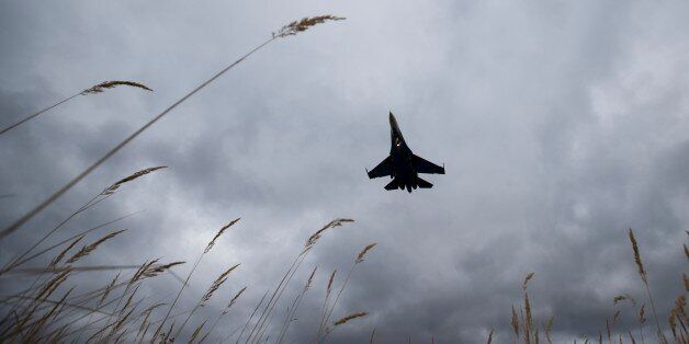 In this photo taken Thursday, Oct. 15, 2015 , a Sukhoi SU-27 jet of the aerobatics team Russian Knights approaches to land at Kubinka Air Base in Kubinka, 65 kilometers (40 miles) outside Moscow, Russia. In Kubinka, a vast workshop that upgrades warplanes of the kind Russia is using in Syria is the townâs main lifeblood, and support for the Syria campaign is strong among the town residents. (AP Photo/Pavel Golovkin)