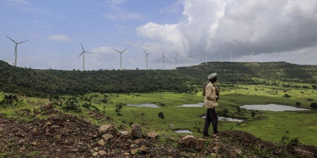 A goat herder walks as wind turbines manufactured by Gamesa Corp. stand at the Bharat Light & Power Ltd. Amberi wind farms in Rewalkawadi, Maharashtra, India, on Tuesday, Sept. 9, 2014. Prime Minister Narendra Modi's government in July restored a wind-farm tax benefit, which could propel wind installations to a three-year high of 2,600 megawatts in 2014, according to Bloomberg New Energy Finance. Photographer: Dhiraj Singh/Bloomberg via Getty Images