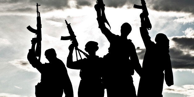 Silhouette of several muslim militants with rifles