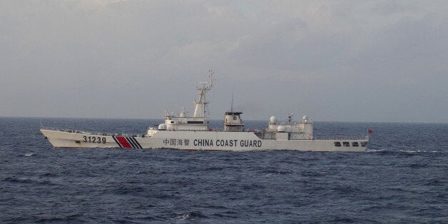In this photo provided by Japan Coast Guard, an armed Chinese coast guard ship sails in the water near islands, known as the