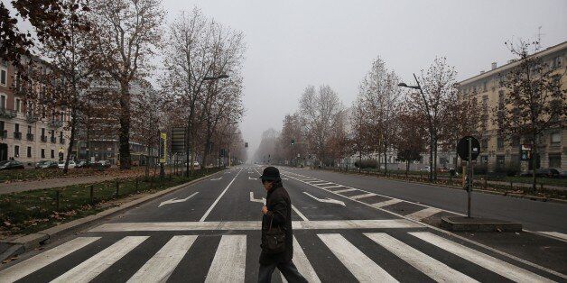 A woman crosses the Corso Sempione in central Milan on December 28, 2015.Drivers in Milan will face a limit on daytime travel three days as the northern Italian city tries to bring air pollution down from dangerous levels. A lack of rainfall has led pollution levels to climb in recent weeks, that has prompted the administration of the Lombardy region, of which Milan is the capital, to appeal to localities to cancel traditional New Year fireworks displays to prevent the smog worsening. / AFP / MARCO BERTORELLO (Photo credit should read MARCO BERTORELLO/AFP/Getty Images)
