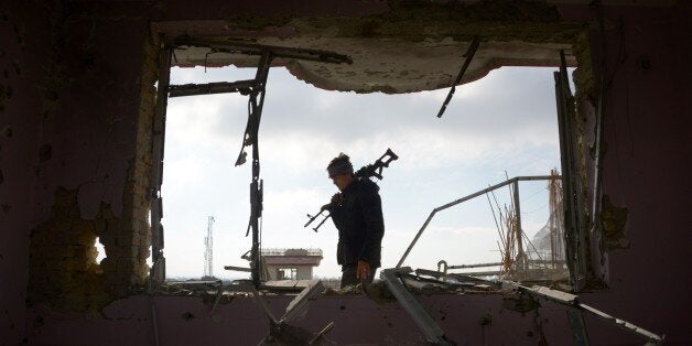 TOPSHOT - An Afghan policeman inspects a building used by insurgents to launch an attack on the Indian consulate, in Mazar-i-
