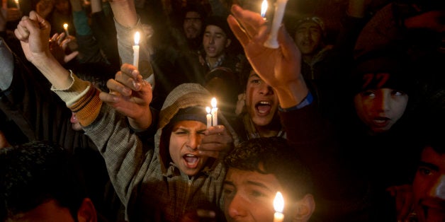 Kashmiri Shiite Muslim boys shout slogans as they hold candles during a protest against Saudi Arabia in Srinagar, Indian cont
