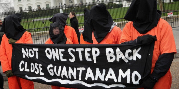 WASHINGTON, DC - JANUARY 08: Demonstrators with the group Witness Against Torture dress in orange jumpsuits and wear black hoods while demanding that U.S. President Barack Obama close the military prison in Guantanamo, Cuba, outside the White House January 8, 2016 in Washington, DC. There are still 104 terrorism detainees from Afghanistan, Yemen, Saudi Arabia, Pakistan and other countries being held at the maximum security prison. (Photo by Chip Somodevilla/Getty Images)