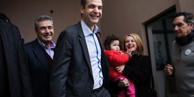 Candidate for the leadership of Greece's conservative New Democracy party, Kyriakos Mitsotakis (C) leaves after casting his b