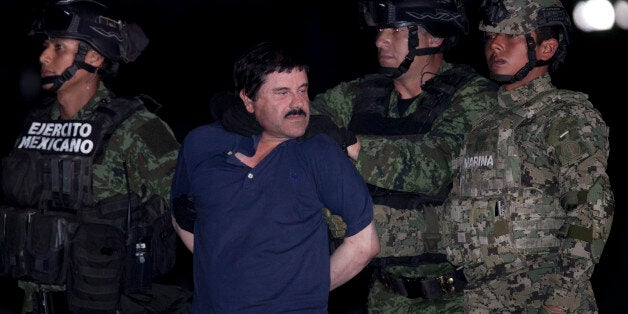 Joaquin "El Chapo" Guzman is made to face the press as he is escorted to a helicopter in handcuffs by Mexican soldiers and marines at a federal hangar in Mexico City, Mexico, Friday, Jan. 8, 2016. Mexican President Enrique Pena Nieto announced that Guzman had been recaptured six months after escaping from a maximum security prison. (AP Photo/Marco Ugarter)