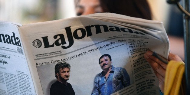 TOPSHOT - A woman reads La Jornada newspaper in Mexico City, on January 10, 2016 which shows a picture of drug lord Joaquin Guzman, aka 'El Chapo' (R), shaking hands with US actor Sean Penn. The Hollywood-worthy recapture of 'El Chapo' took a stunning turn Sunday as authorities sought to question Penn over his interview with the Mexican drug kingpin. A federal official told AFP that the attorney general's office wants to talk with Penn and Mexican actress Kate del Castillo about their secretive meeting with Guzman in October, three months before his capture on January 8. AFP PHOTO / ALFREDO ESTRELLA / AFP / ALFREDO ESTRELLA (Photo credit should read ALFREDO ESTRELLA/AFP/Getty Images)