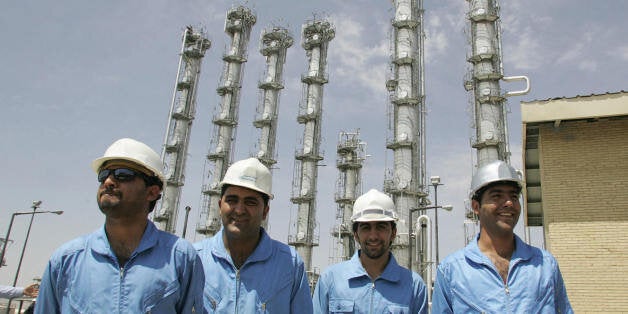 Arak, IRAN: Iranian employees pose for a picture at the newly opened heavy water plant in Arak, 320 kms south of Tehran, 26 August 2006. Iranian President Mahmoud Ahmadinejad opened a heavy water plant today that will feed a new research reactor, just five days before a UN Security Council deadline to suspend sensitive nuclear fuel cycle work. Inaugurating the facility along with the head of Iran's Atomic Energy Organisation, Gholam Reza Aghazadeh, and his deputy, Mohammad Saeedi, Ahmadinejad vowed the Iranian people would defend their rights to nuclear technology 'with force'. AFP PHOTO/ATTA KENARE (Photo credit should read ATTA KENARE/AFP/Getty Images)