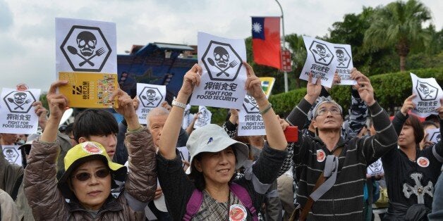 Local residents display signs demanding better food safety during a demonstration in Taipei on December 12, 2015. Hundreds of Taiwanese took to the streets to protest the acquittal of a tycoon accused of selling tainted cooking oil, in a string of food scandals that sparked widespread anger. AFP PHOTO / Sam Yeh / AFP / SAM YEH (Photo credit should read SAM YEH/AFP/Getty Images)